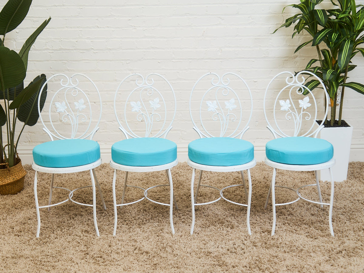 Vintage Wrought Iron Patio Dining Table with Leaf Motif Aqua Cushions and Glass Top