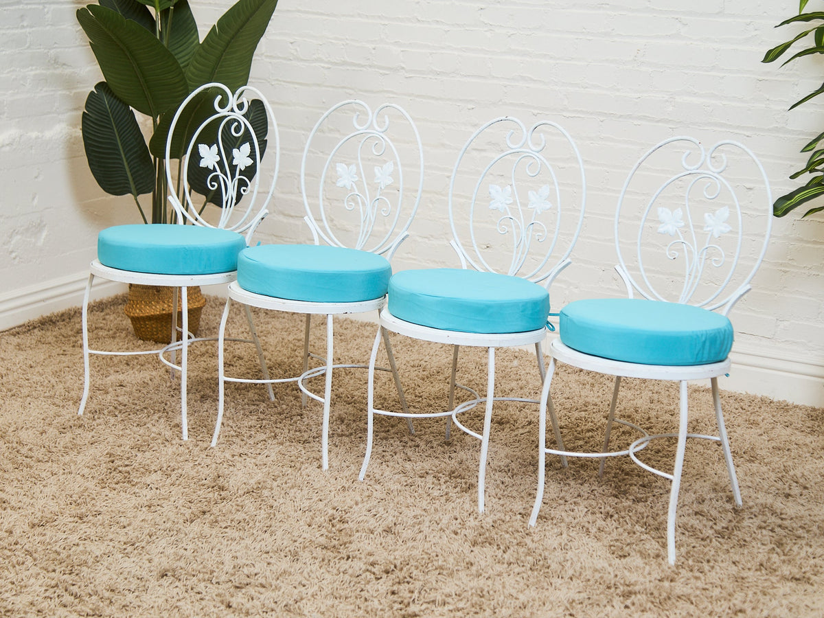 Vintage Wrought Iron Patio Dining Table with Leaf Motif Aqua Cushions and Glass Top