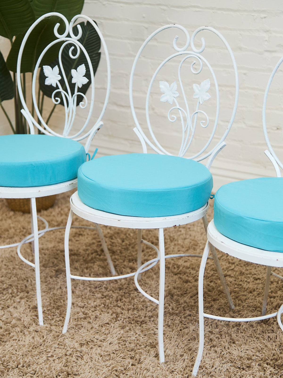 Vintage Wrought Iron Patio Dining Table with Leaf Motif Aqua Cushions and Glass Top