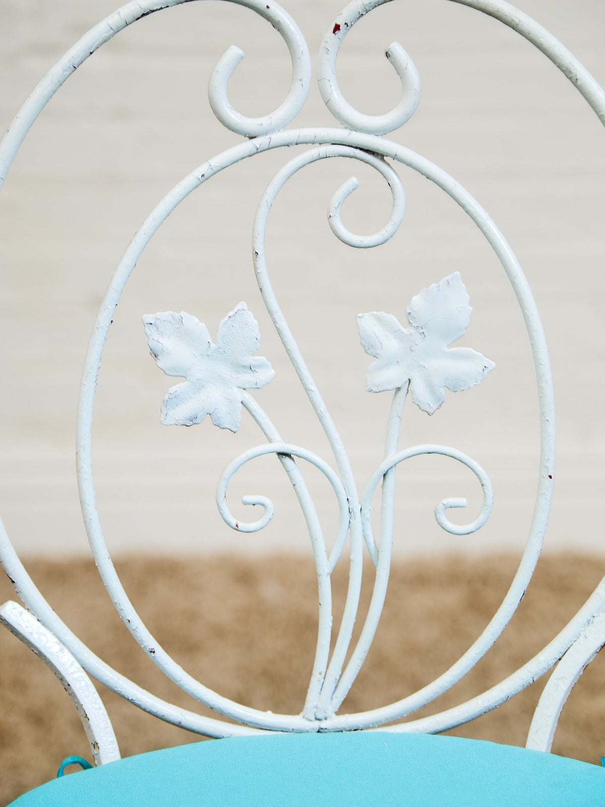 Vintage Wrought Iron Patio Dining Table with Leaf Motif Aqua Cushions and Glass Top